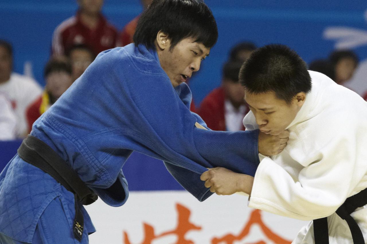 一名穿藍色柔道服的選手與一名穿白色柔道服的選手正在進行柔道比賽