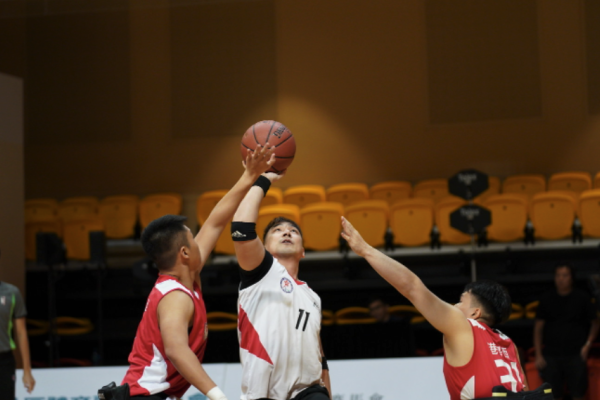 輪椅籃球運動員越過防守者投籃