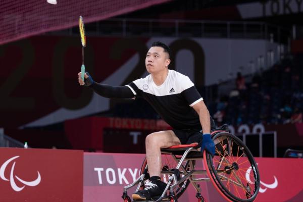 男子輪椅羽毛球選手揮拍擊球